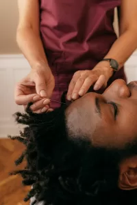 woman performing facial acupuncture